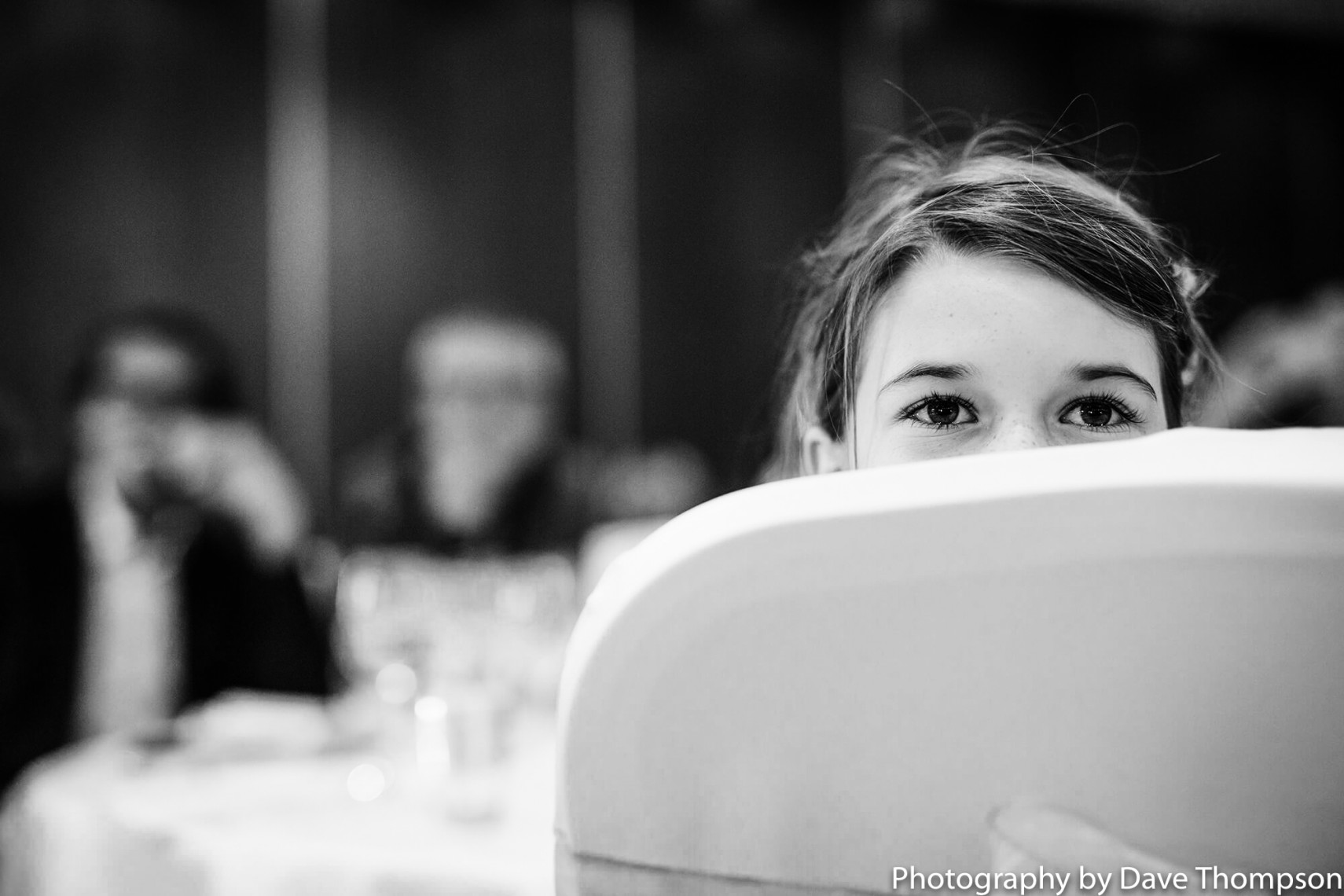 A young guests peeps over a chair during the speeches