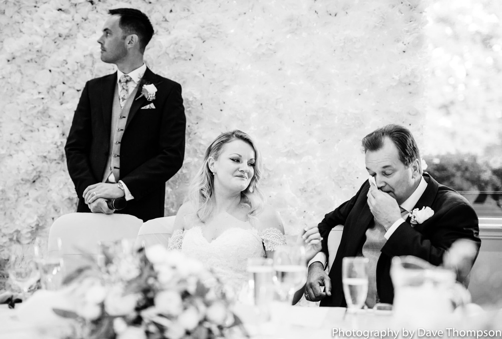 The bride smiles as her father cries 