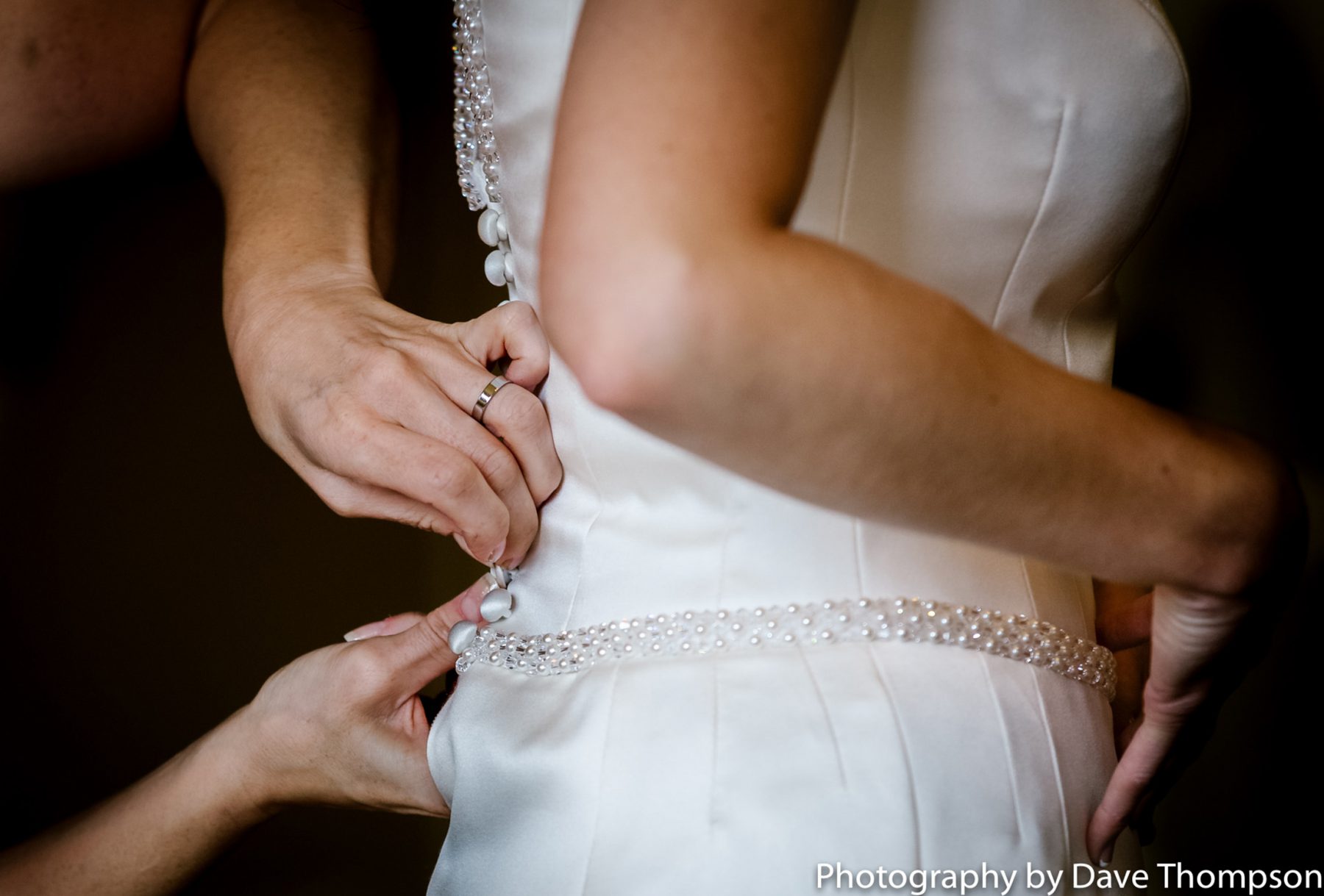Final few buttons on the bridal dress are done