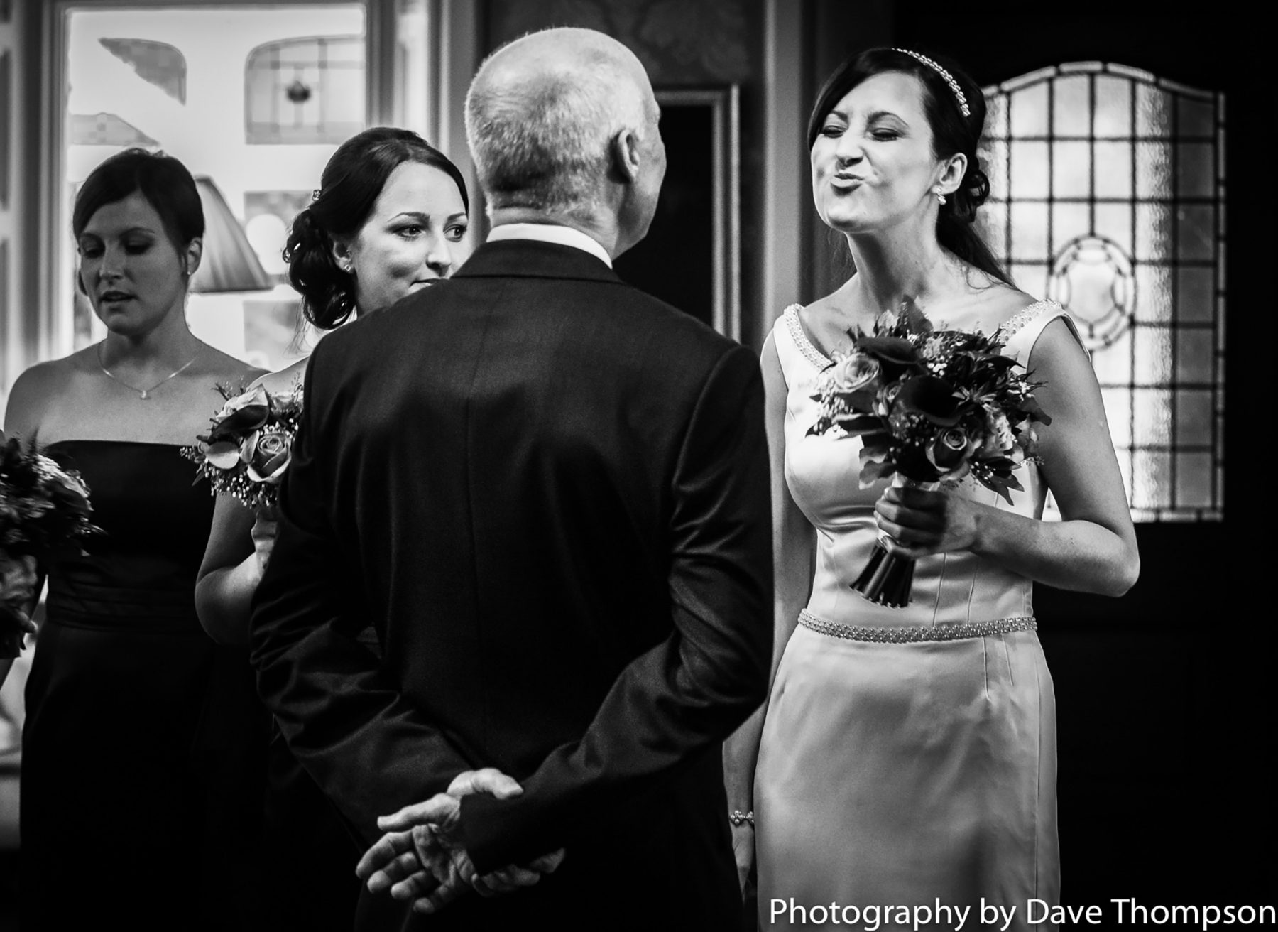 The bride playfully puckers up her lips towards her father