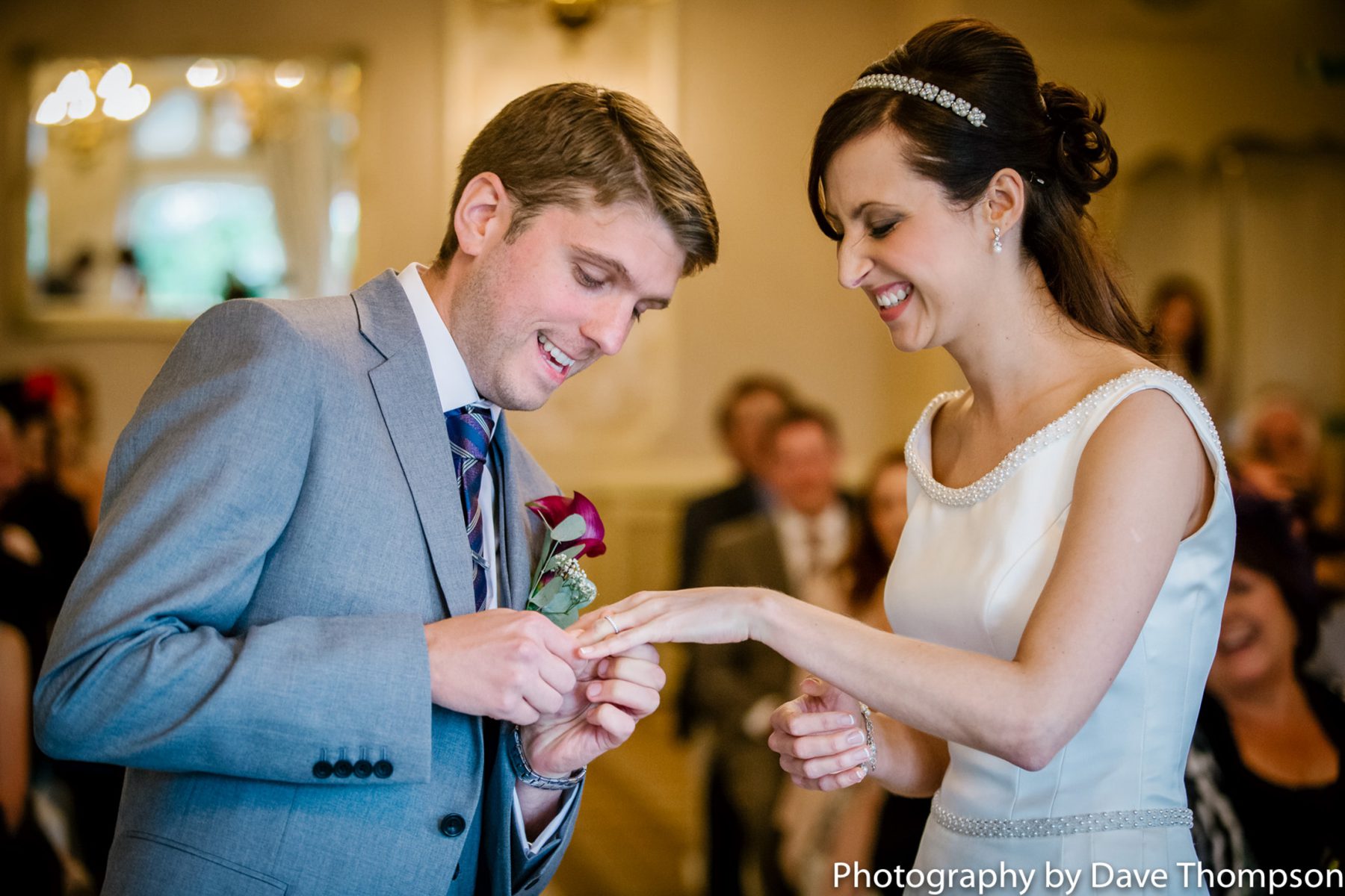 The groom places the ring on the brides finger.