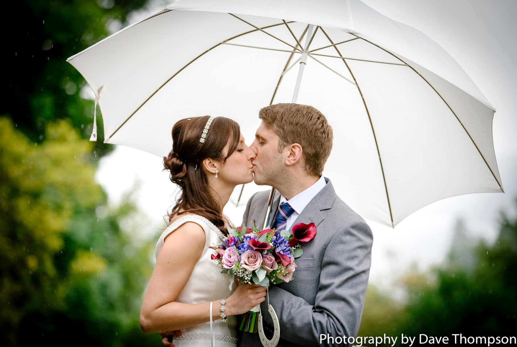 Bride and groom beneath an umbrella