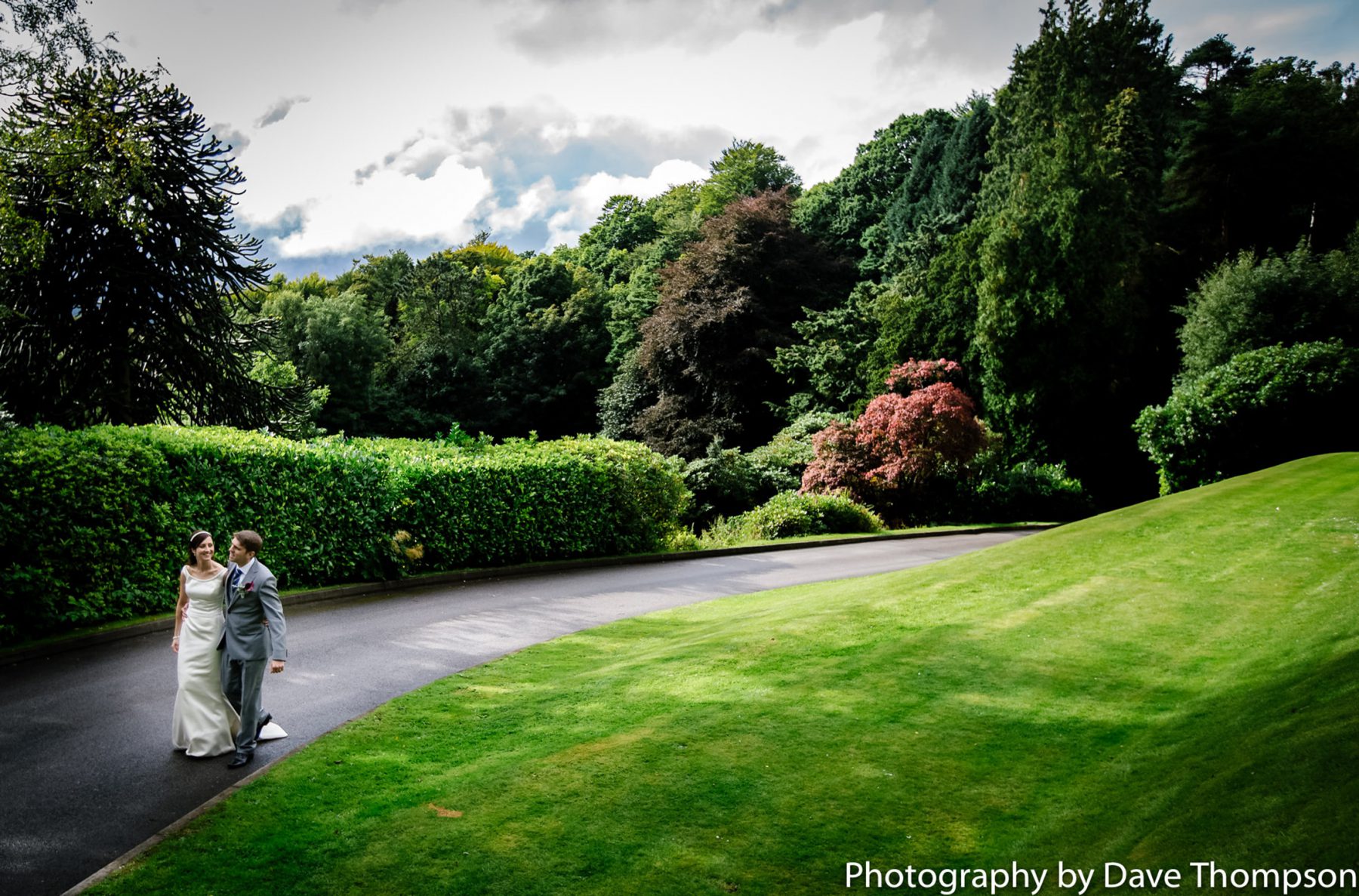 The bride and groom walk up the winding driveway at Merewood Country House Hotel.