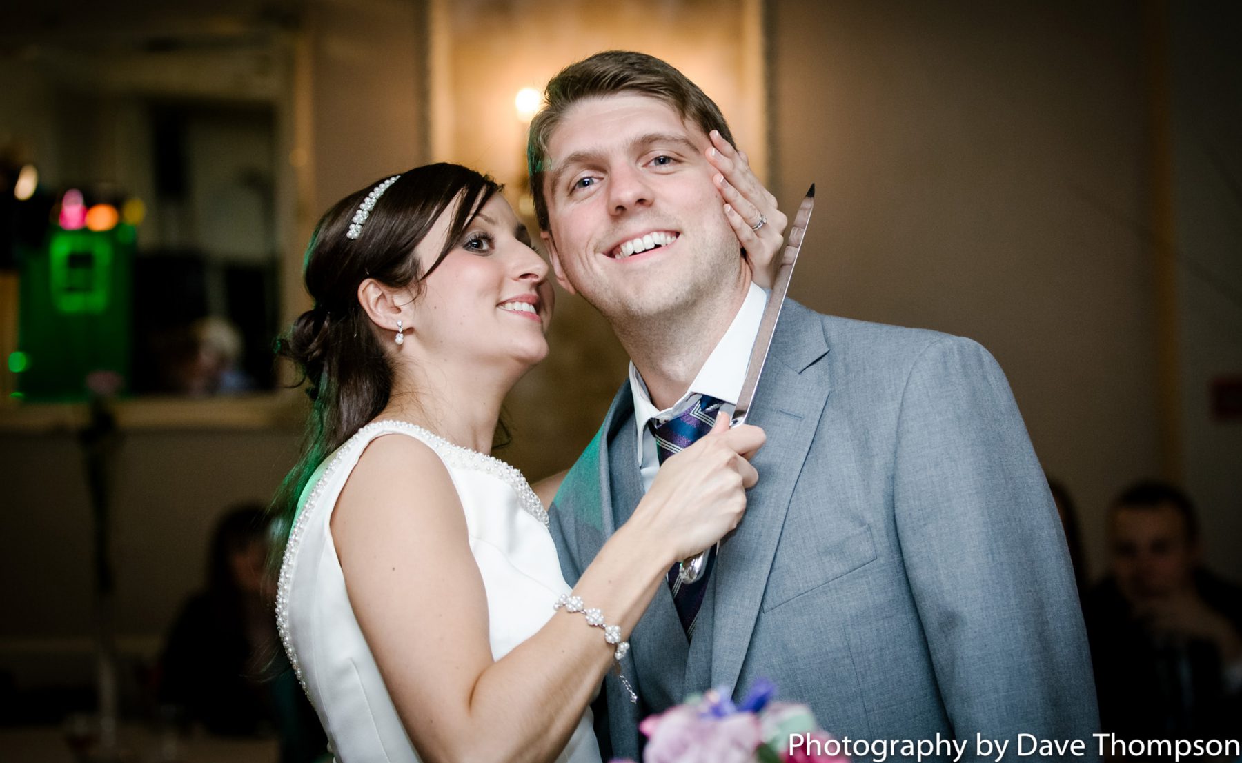 Cake cutting as the bride hold the knife to the grooms neck