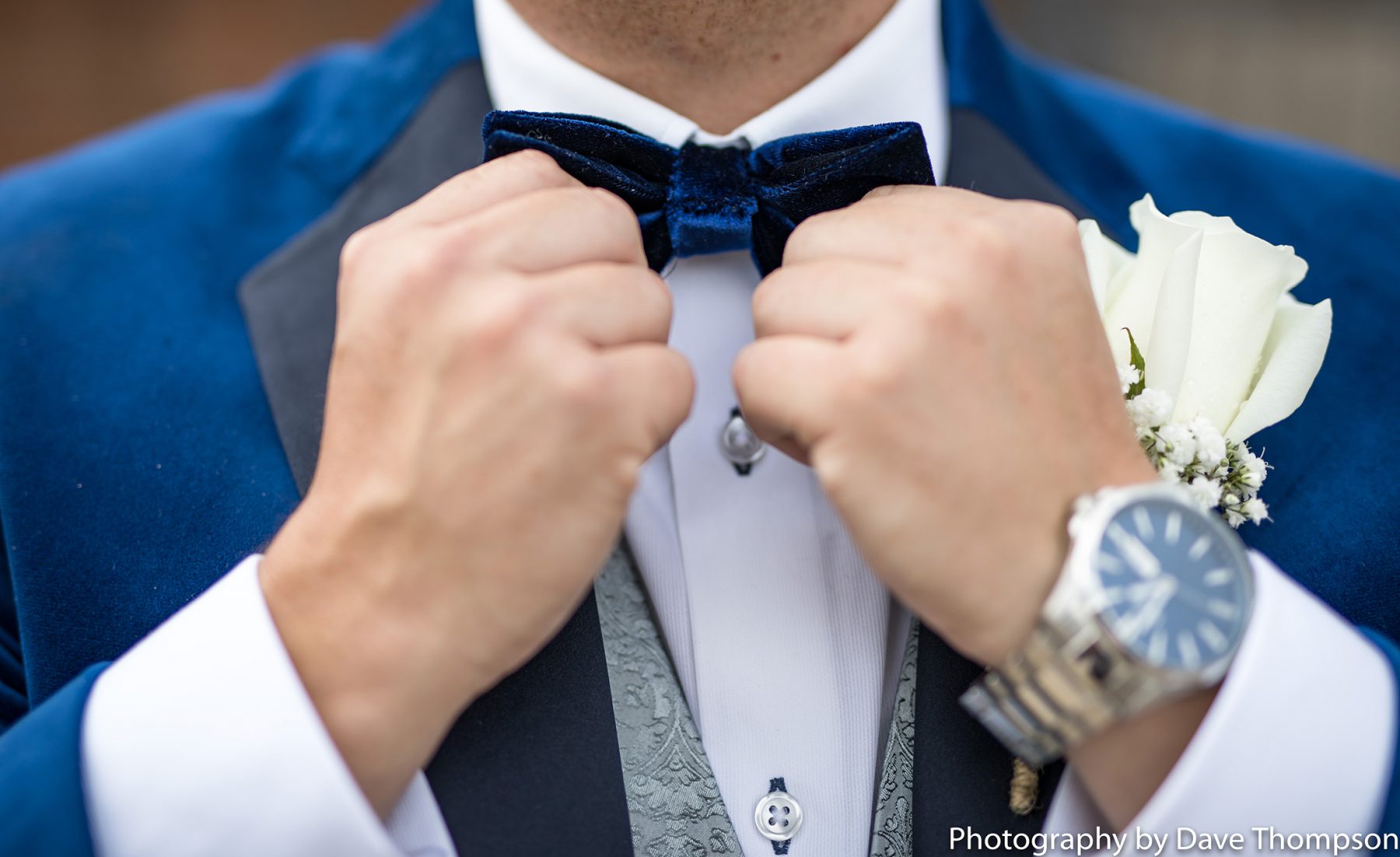 The groom adjusts his bow tie