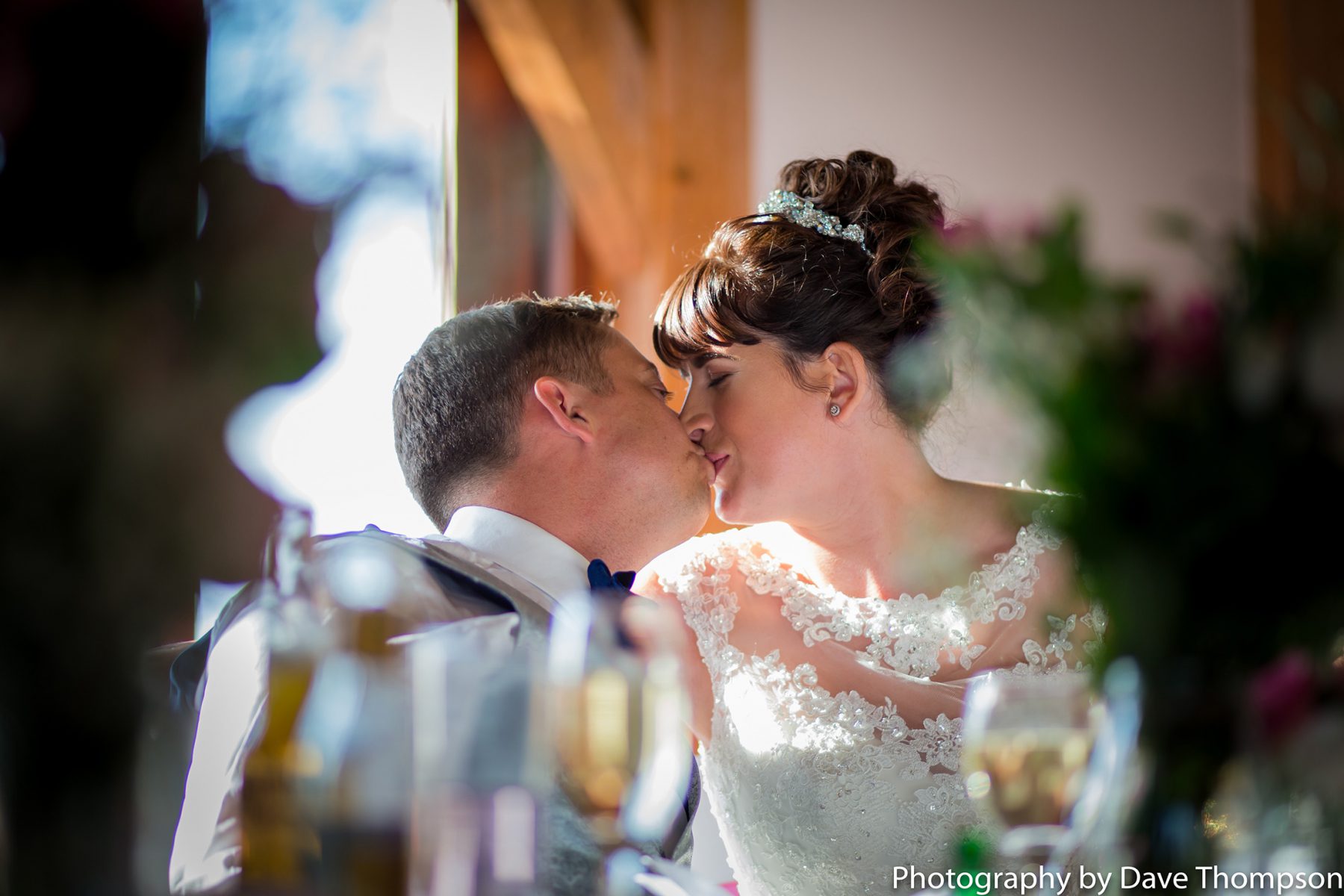 The bride and groom share a kiss during the wedding breakfast