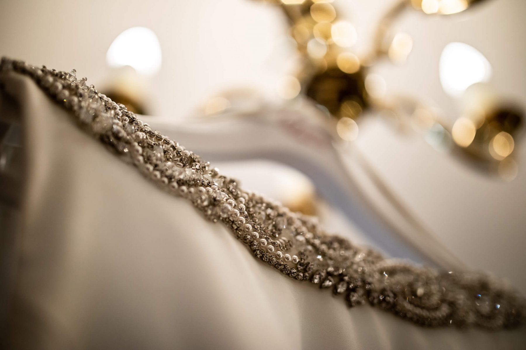 A wedding dress hangs from a light fitting.