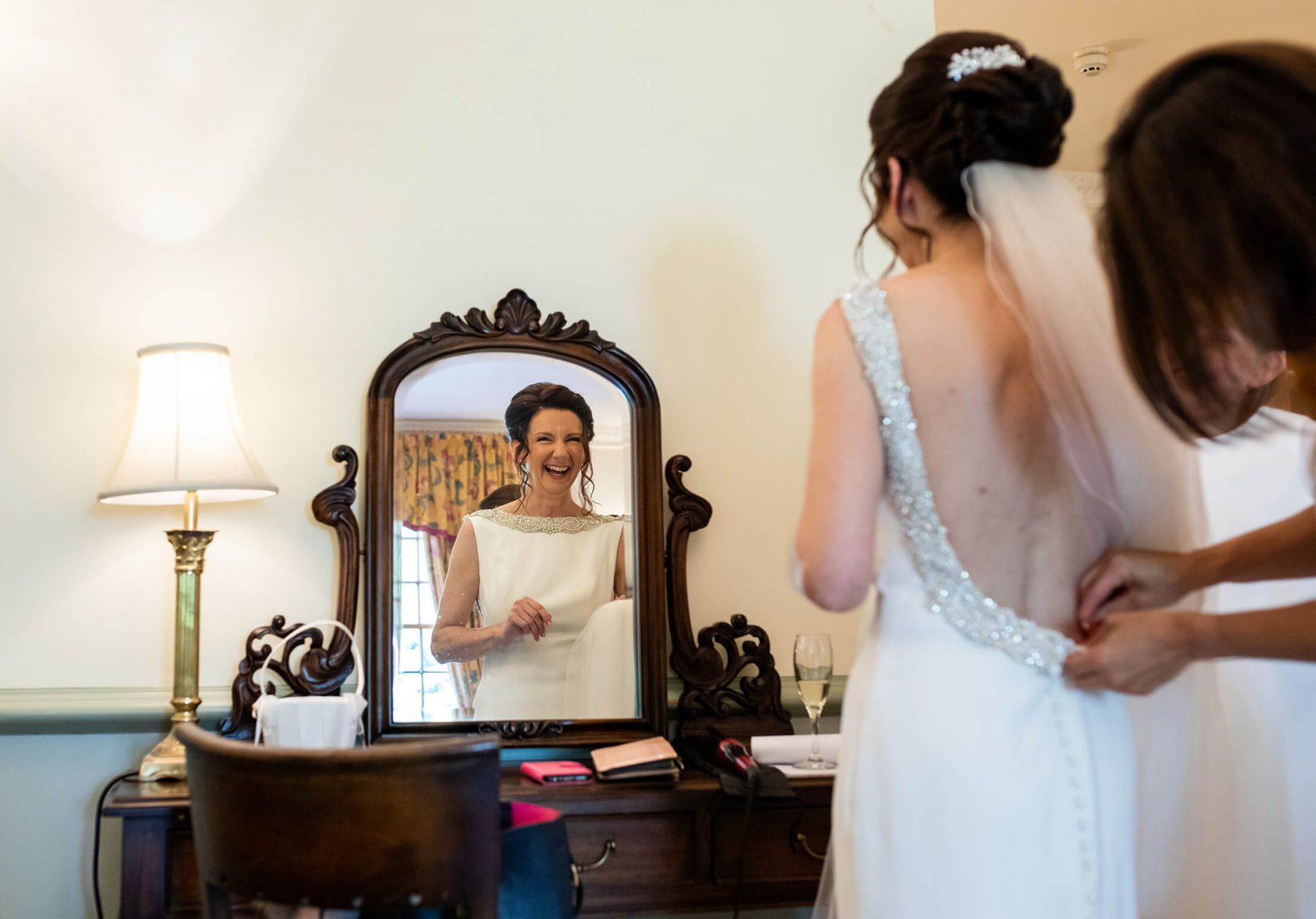 A bride is reflected in a mirror.