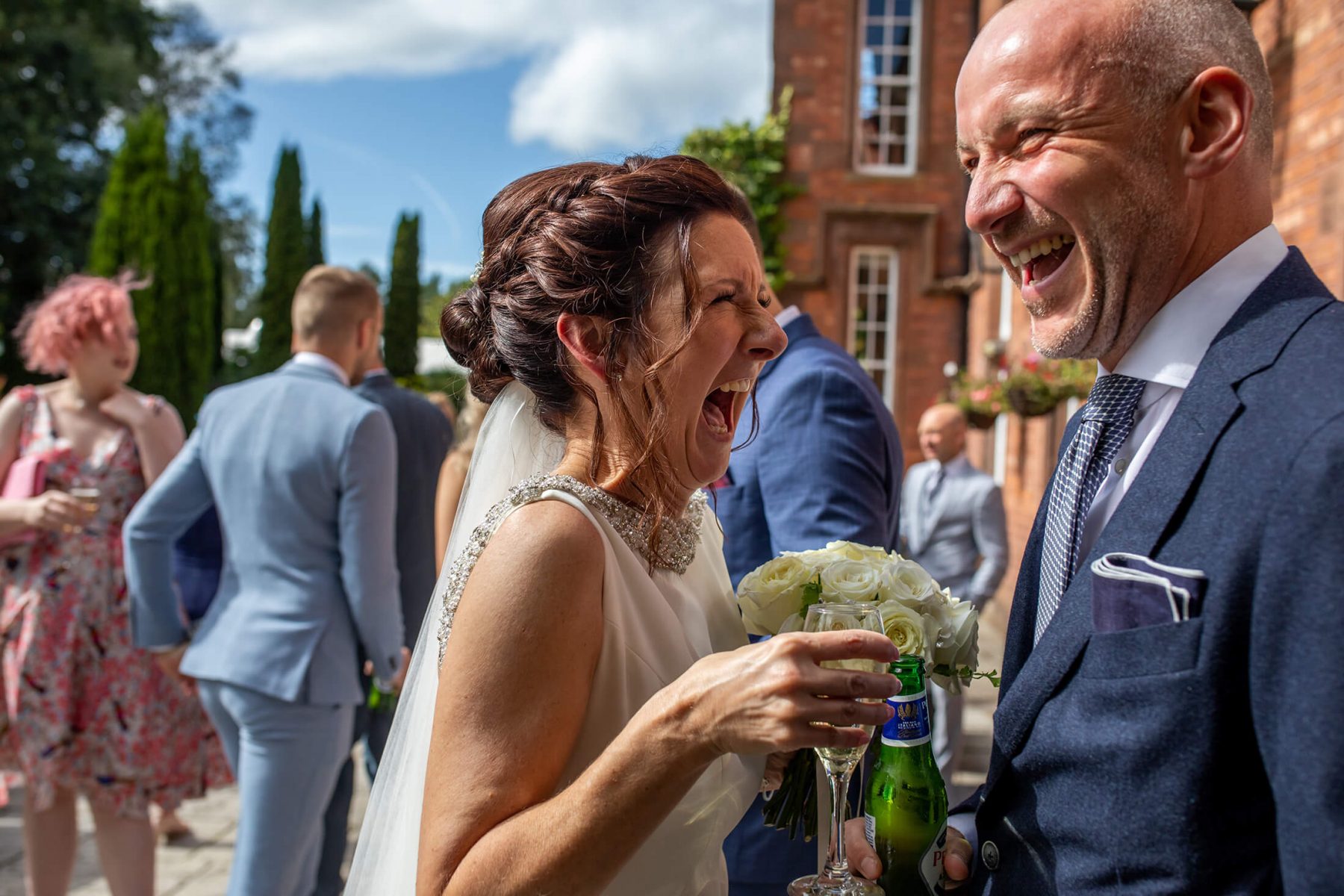 The bride laughs with her bother after her wedding.