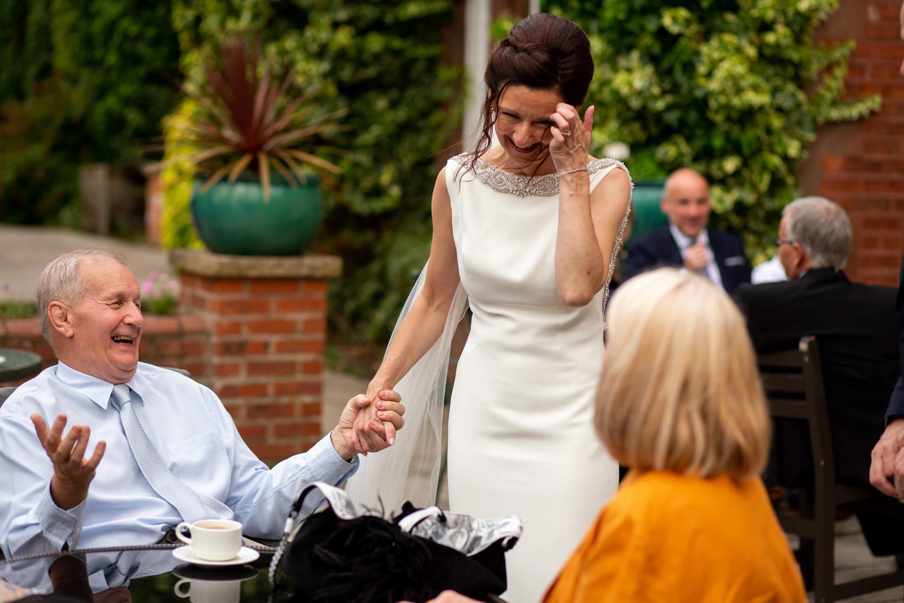 The bride laughs with a wedding guest