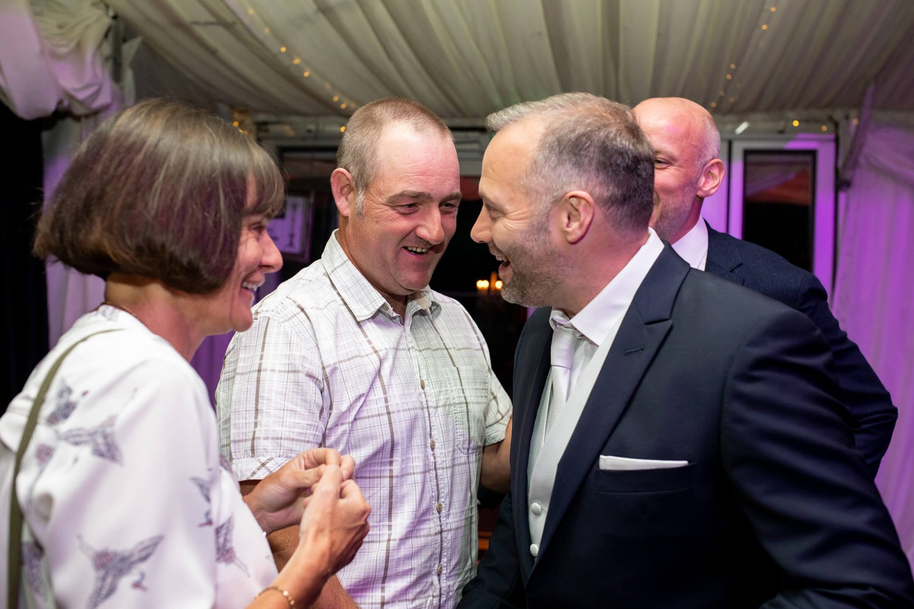 The groom chats with evening guests.