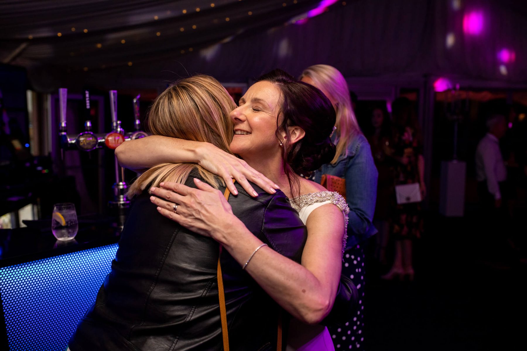 The bride hugs an evening guest