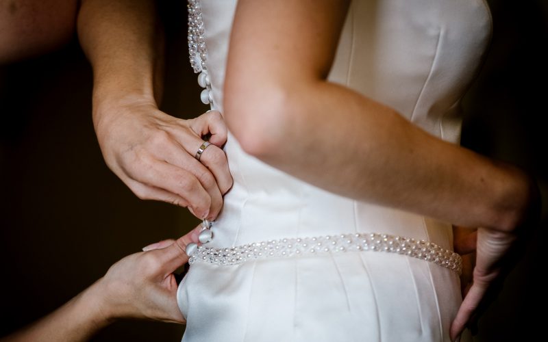 Final few buttons on the bridal dress are done