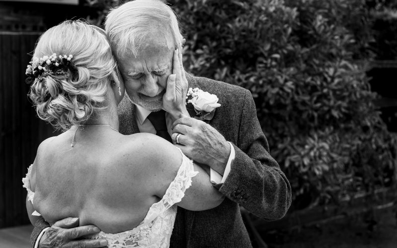The father of the bride cries as he sees his daughter for the first time in her wedding dress.
