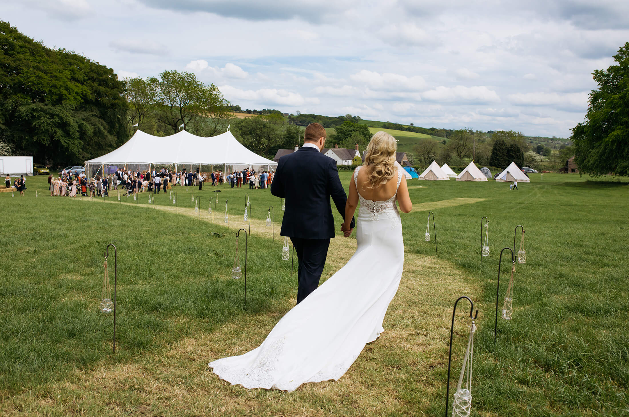 The bride and groom make their way to the marquee for their wedding celebrations.