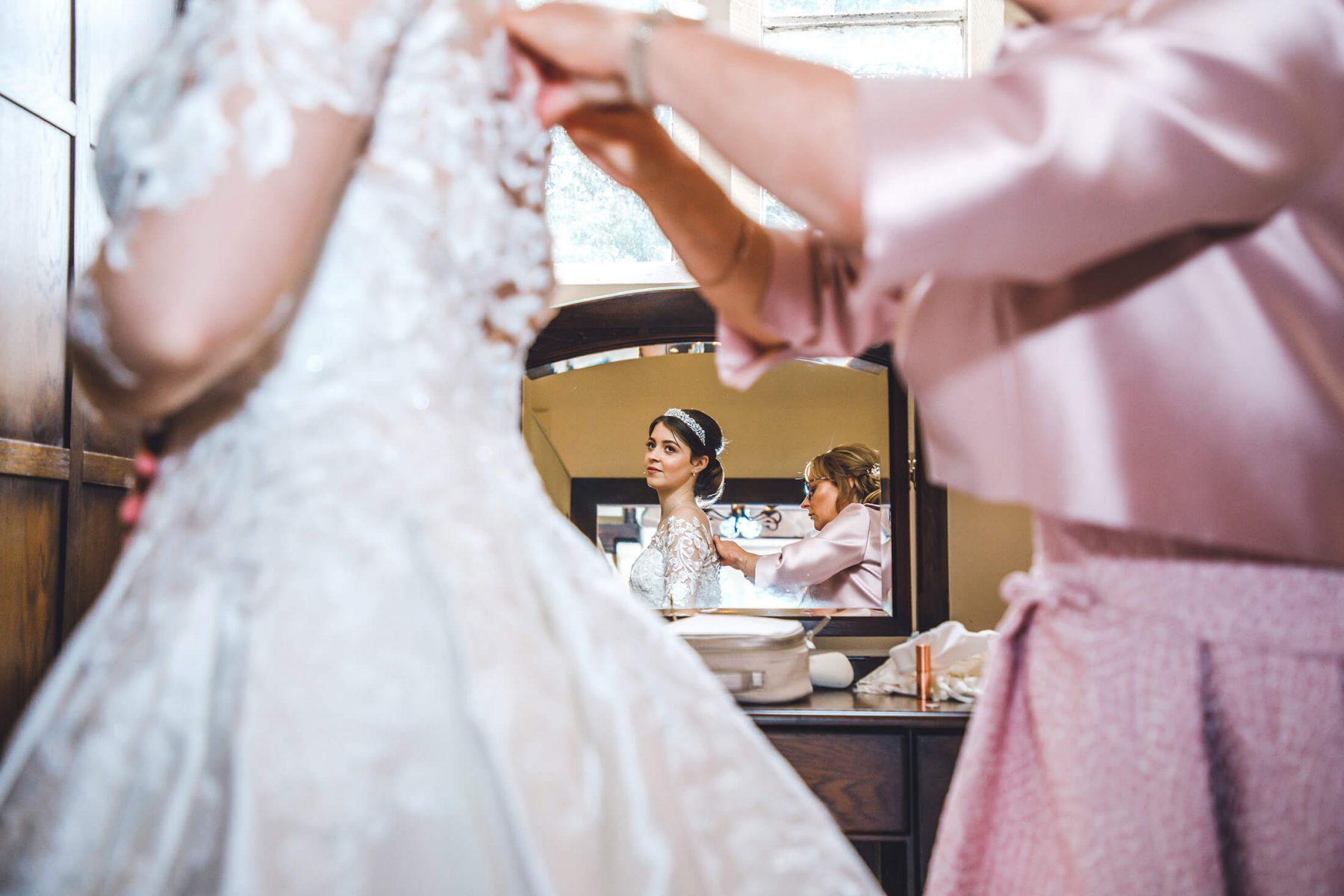 A reflection of a bride in a mirror during bridal prep
