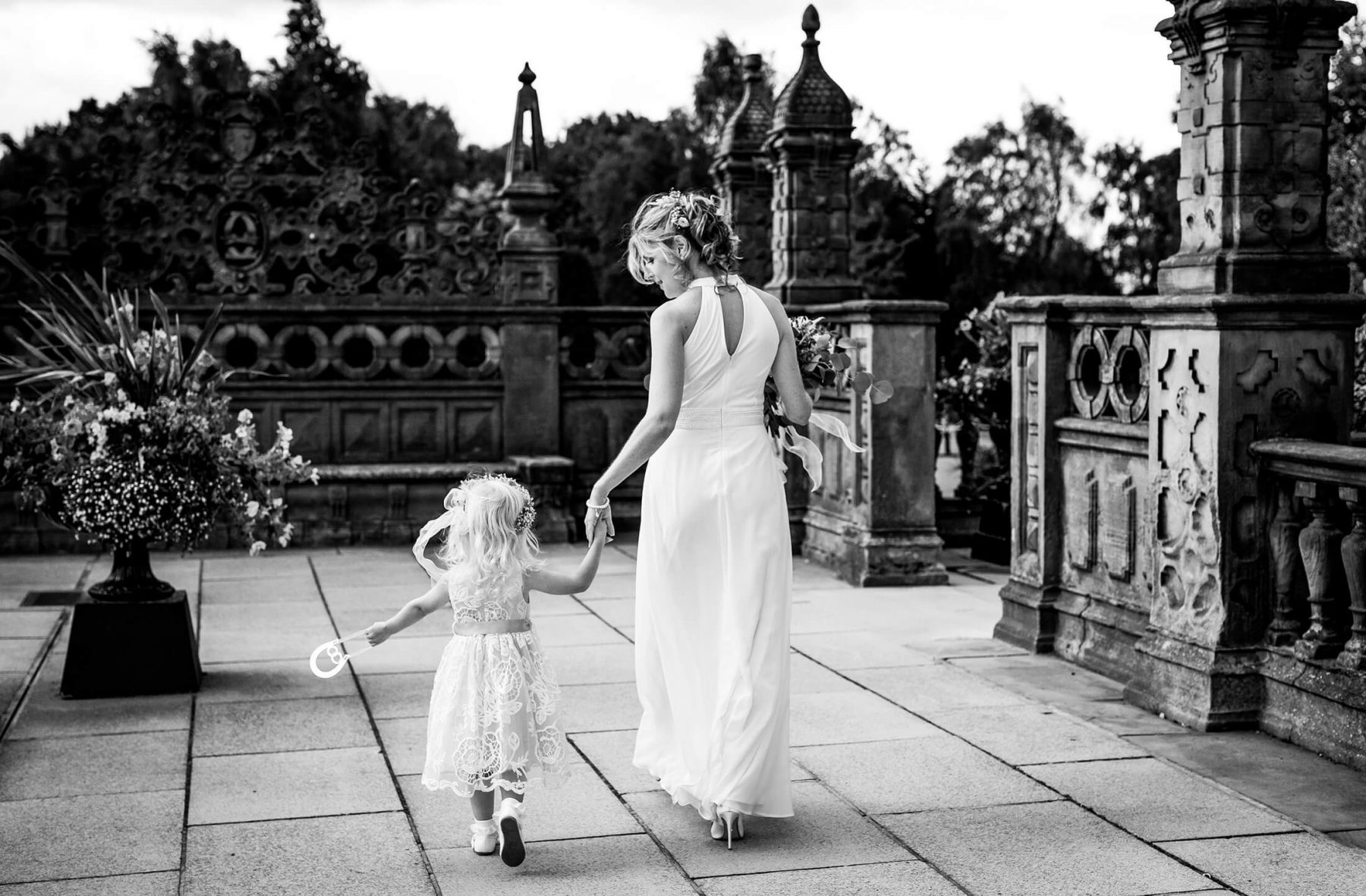 Natural wedding photography The bride holds hands with her daughter as she leaves Crewe Hall after geting ready for her wedding. Crewe Hall Wedding Photographer