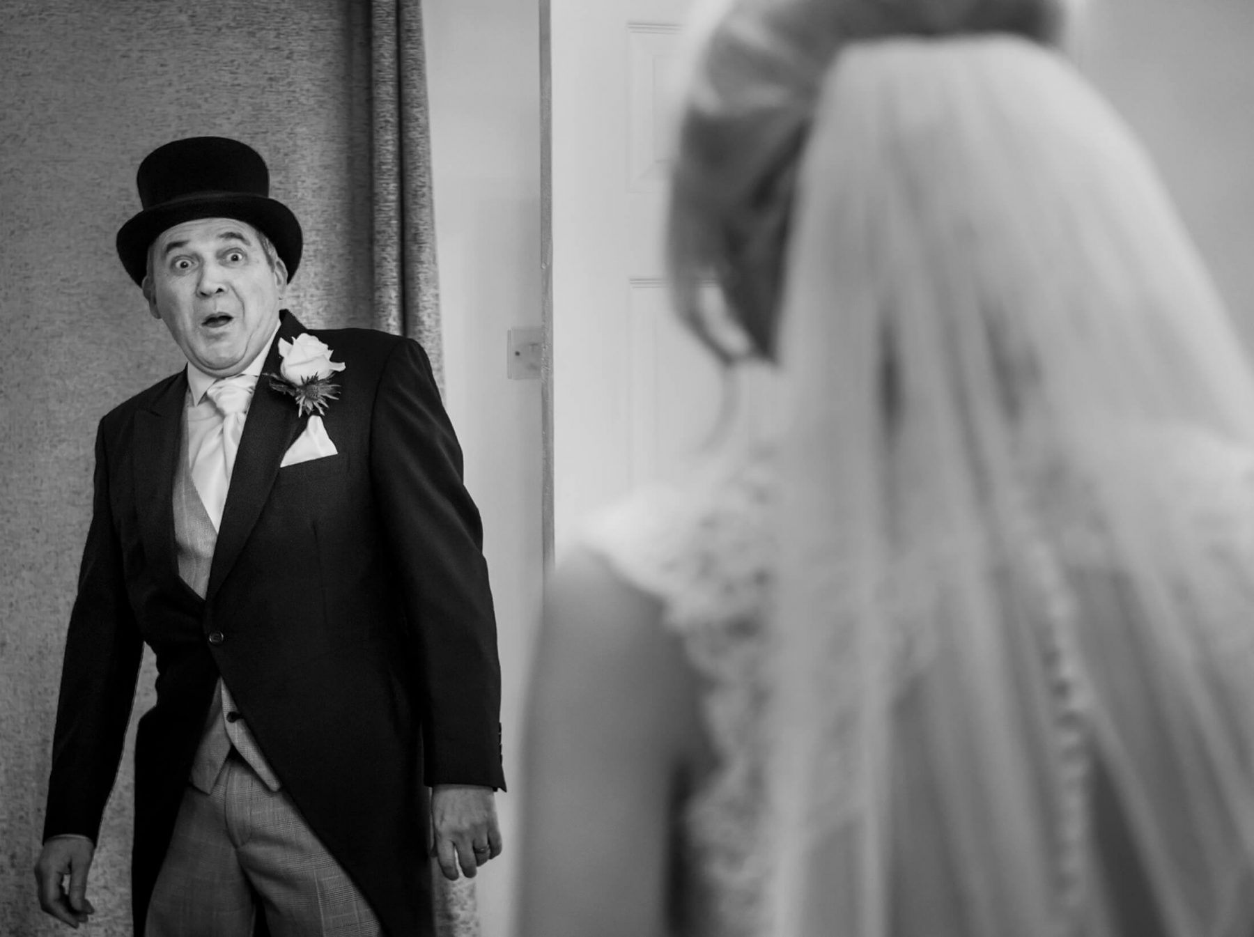 The father of the bride looks surprised as he see his daughter in her wedding dress for the first time. Wychwood Park wedding photographer