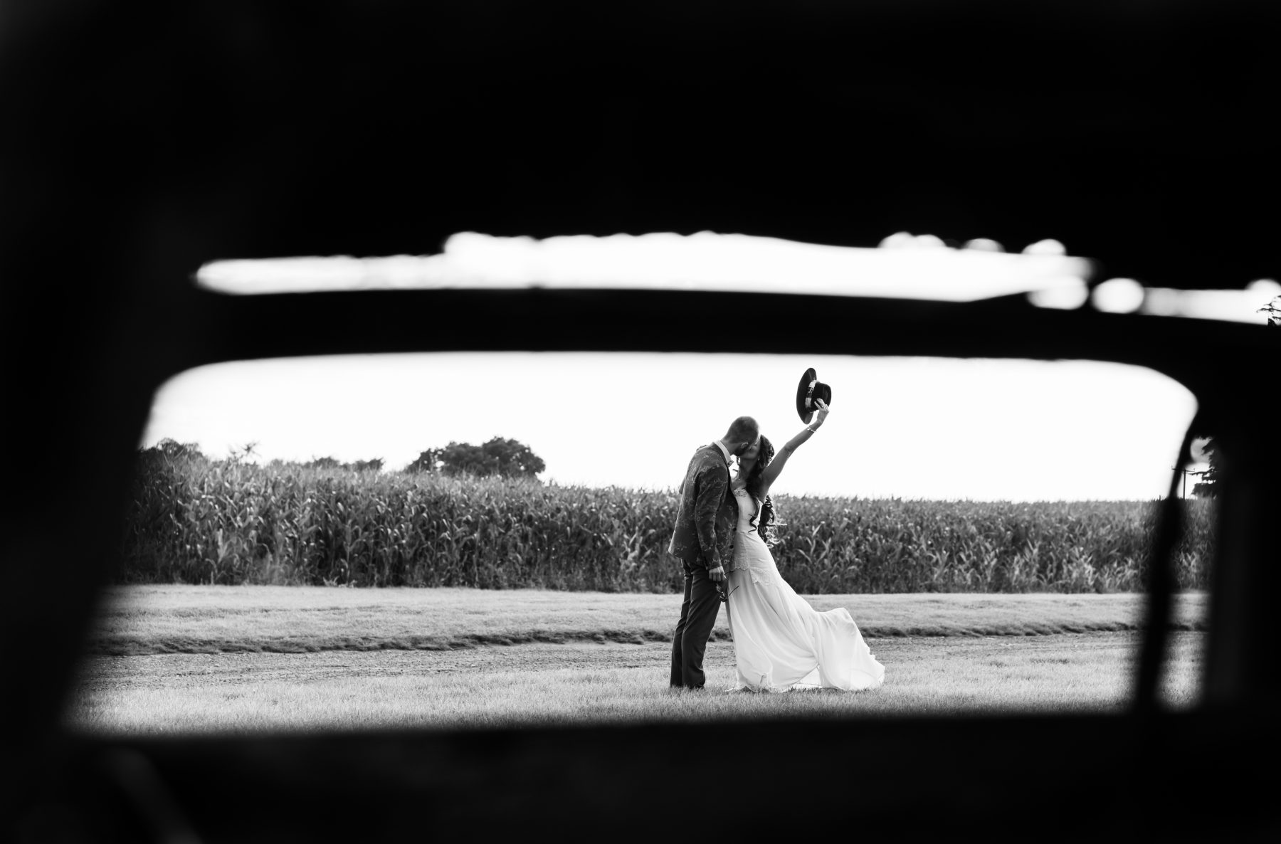 A bride and groom share a kiss at Alcumlow Wedding Barn