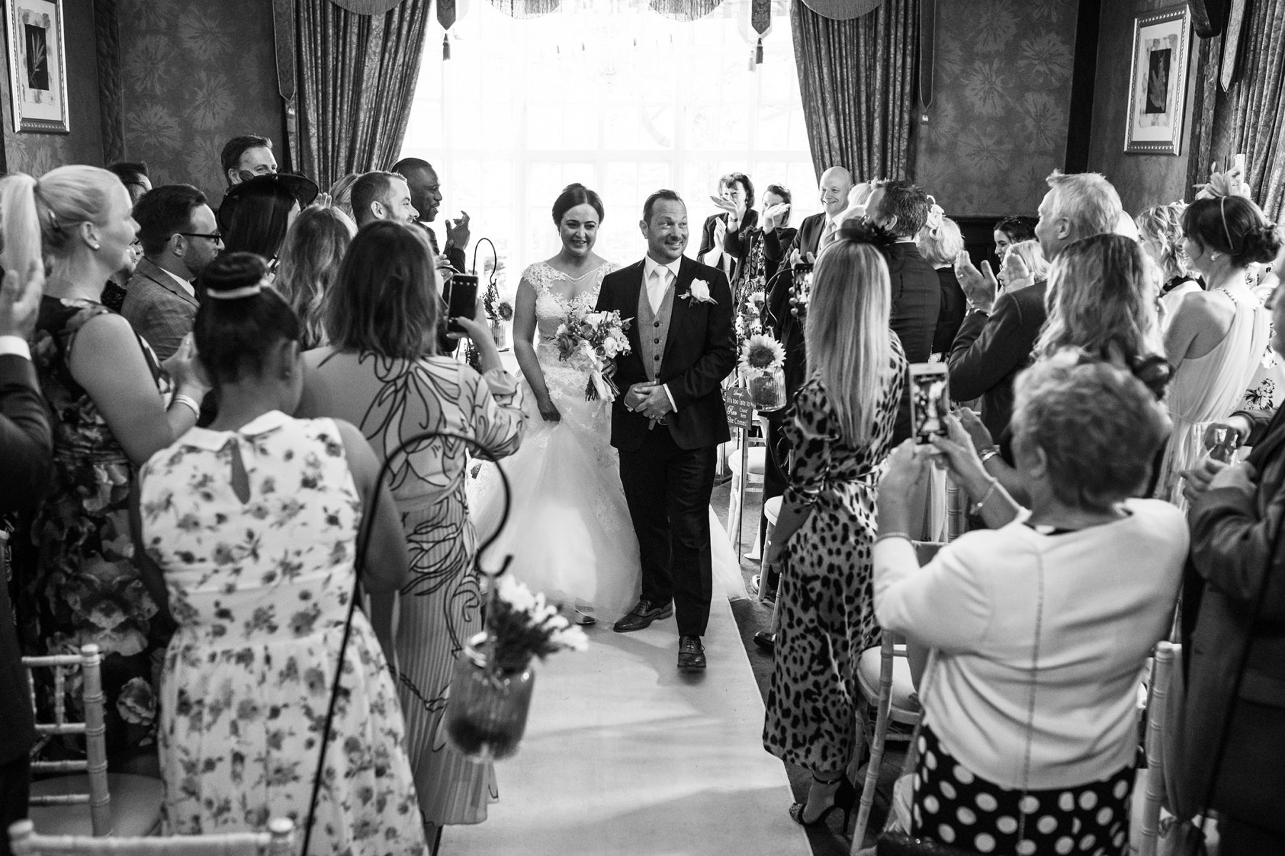 The bride and groom make their way back down the aisle after their wedding at Mere Court Hotel, a historic Knutsford Wedding Venues