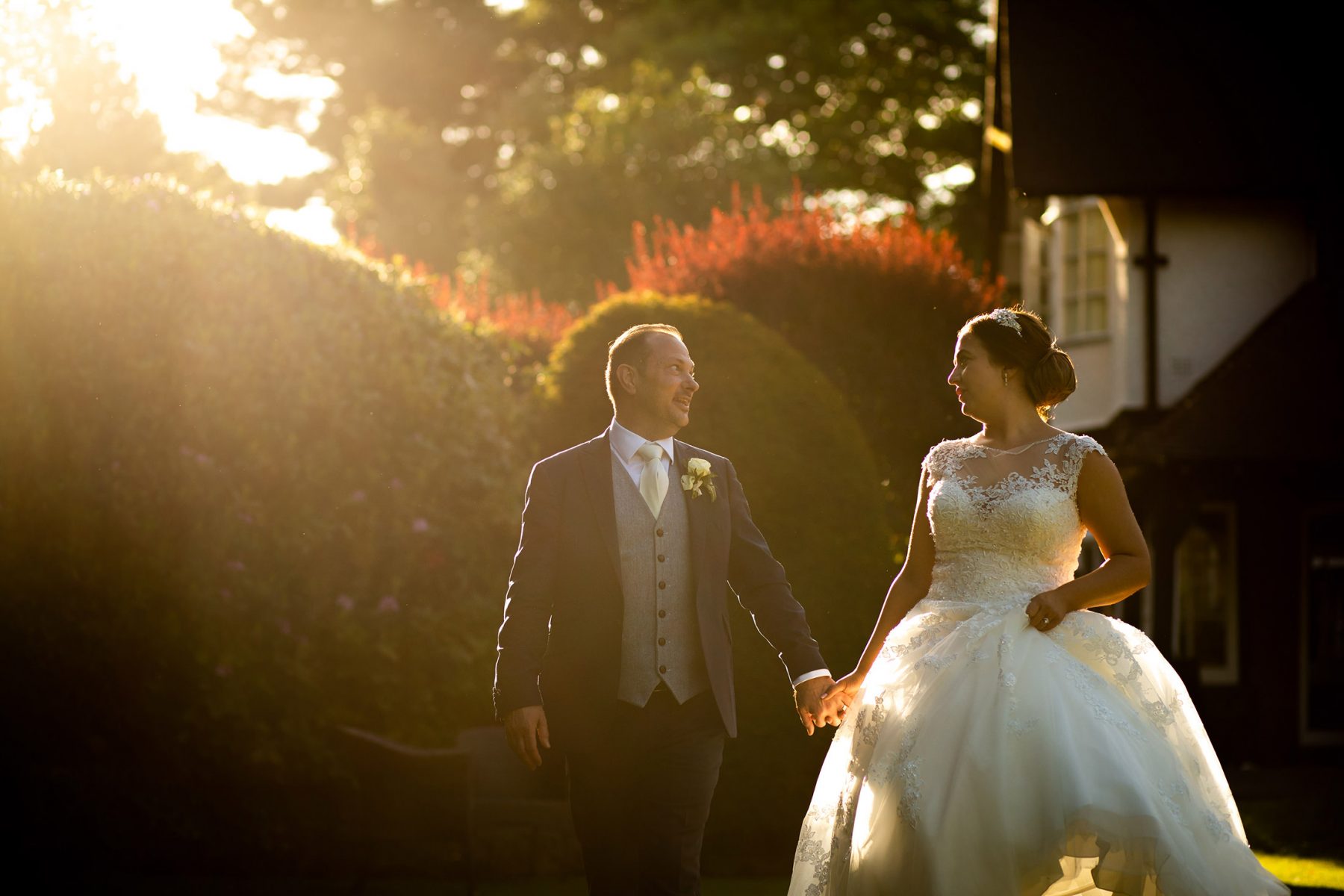 The bride and groom laugh in evening sunlight