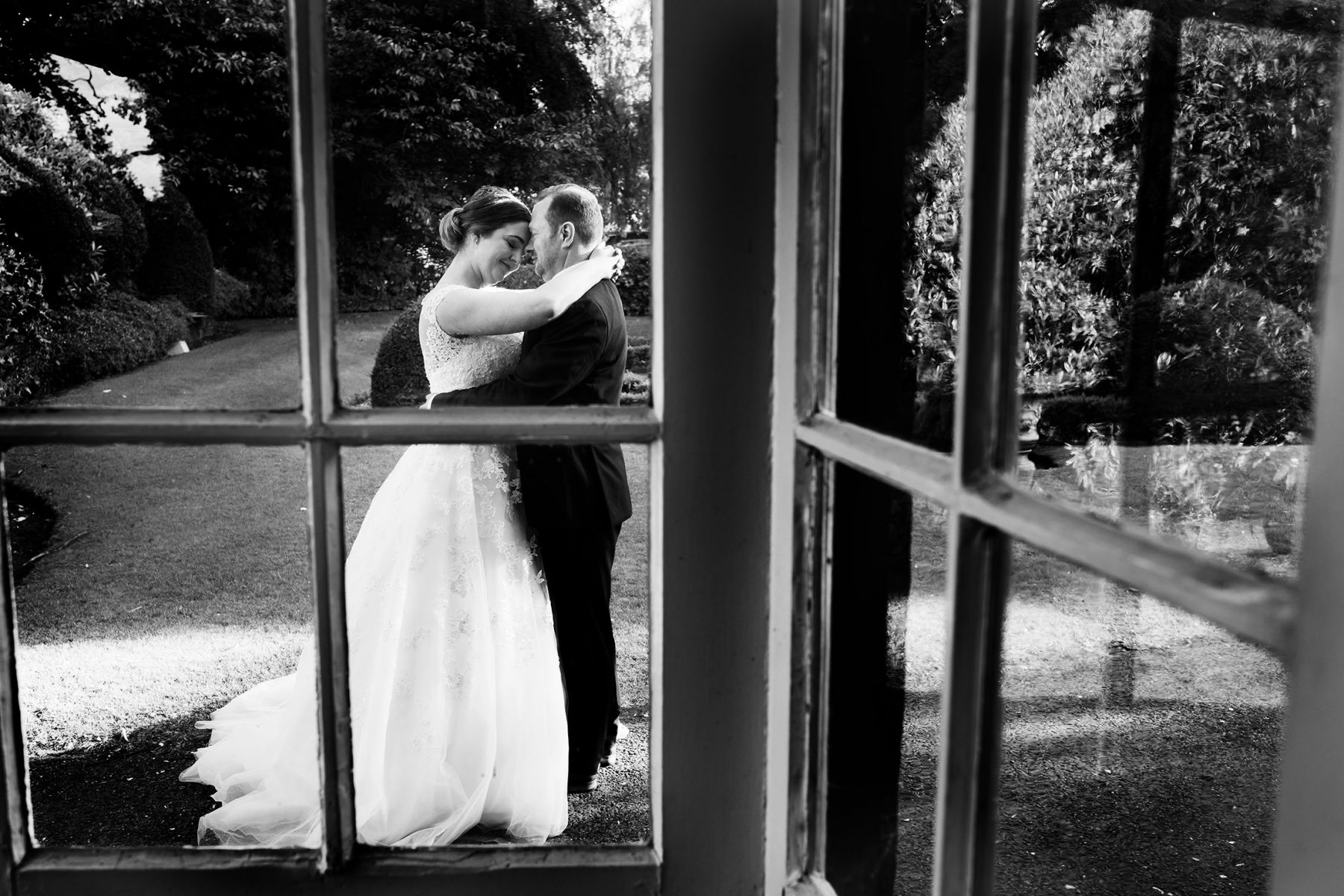 Newleyweds seen hugging though a window